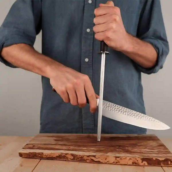 The model is holding the honing steel at a 15 degree angle to the knife for sharpening.