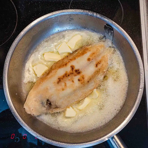 The sole fish is gently flipped over.