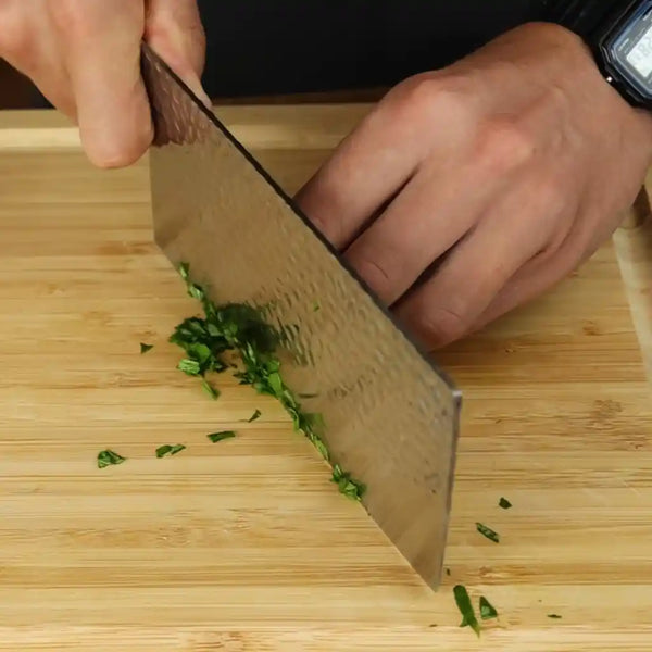 Using a KOTAI Pakka Japanese stainless steel cleaver knife to Chiffonade cut the herbs.