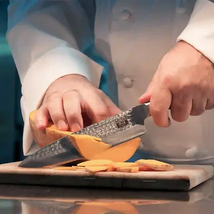 Le modèle coupe sans effort une citrouille avec le couteau de chef japonais Gyuto de KOTAI.