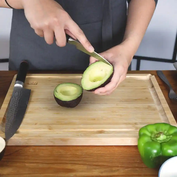 Model splitting the avocado into two halves.