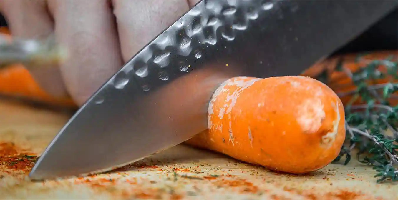 KOTAI's gyuto chef knife slicing a carrot.