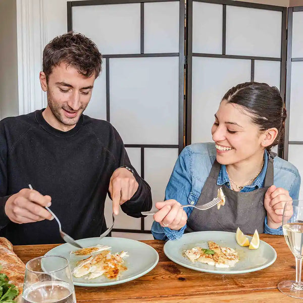 Two team members of KOTAI are tasting the dish with a smile on their face. 