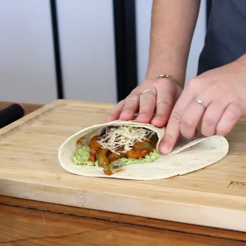 Model is wrapping up the tortillas on KOTAI bamboo cutting board.