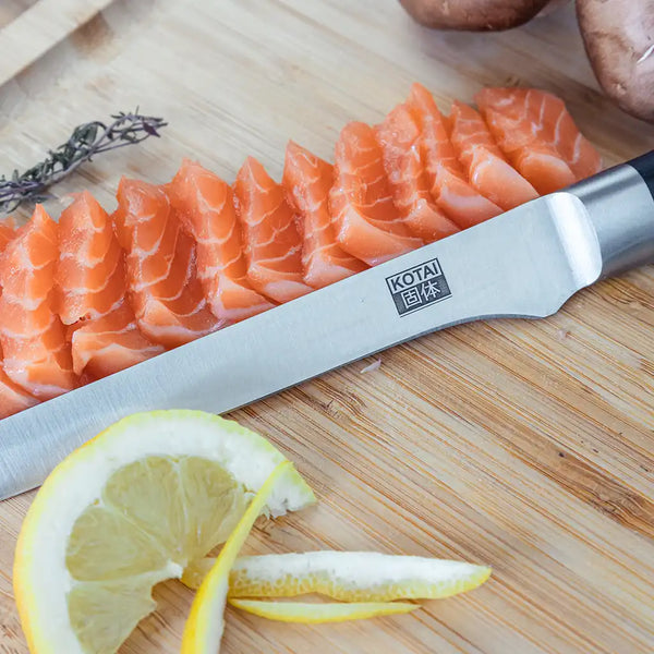KOTAI's Fillet Knife displayed on the KOTAI's cutting board, next to salmon slices and a sliced lemon.