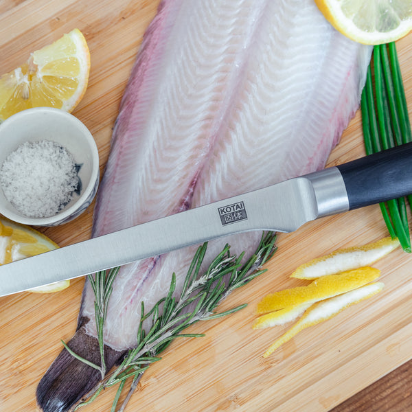 kotai's fillet knife surrounded with some ingredients such as fish, lemon, herbs, etc.