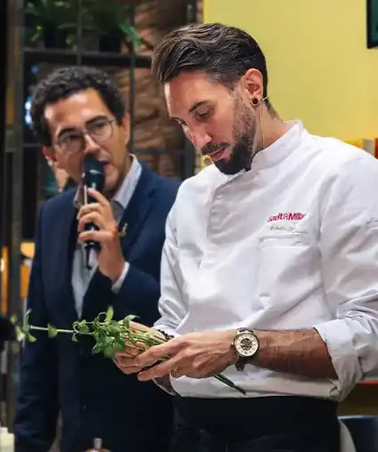 Chef Romain Casas triant des herbes avec ses mains.