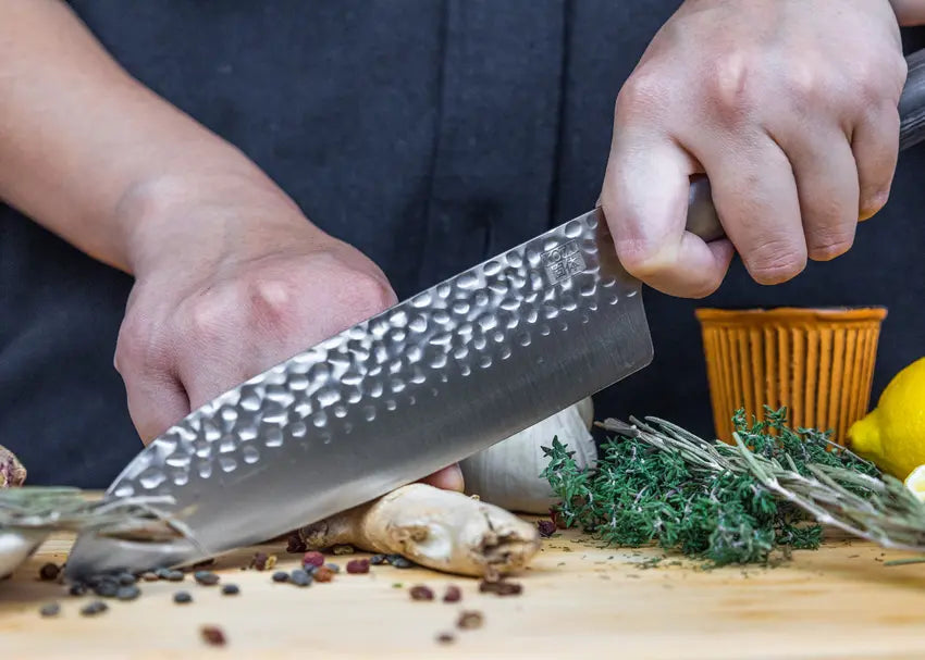 Couteau Santoku Pakka fait main coupant aisément des ingrédients avec une belle lame martelée.