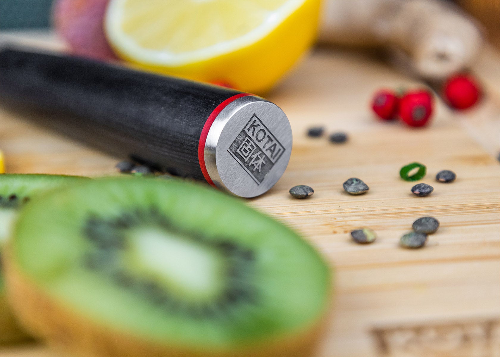 Close-up of KOTAI logo on Paring knife pakkawood handle on bamboo cutting board.
